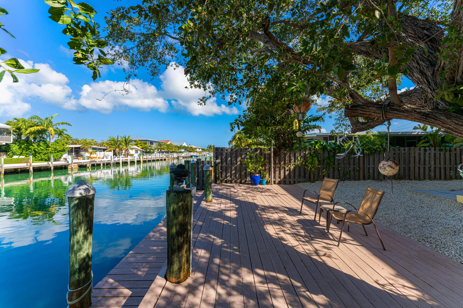 391 10th Street Key Colony Beach, FL 33051 - Photo 42 of 51 a view of a patio with table and chairs potted plants with wooden fence