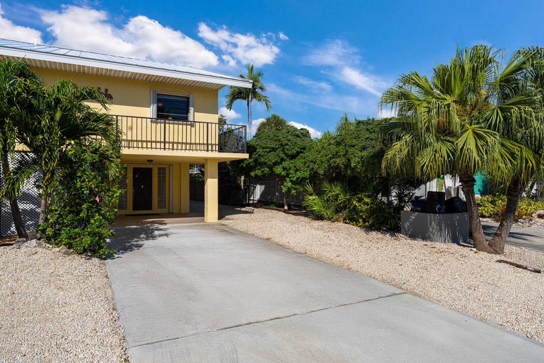 391 10th Street Key Colony Beach, FL 33051 - Photo 9 of 51 a front view of a house with a yard and garage