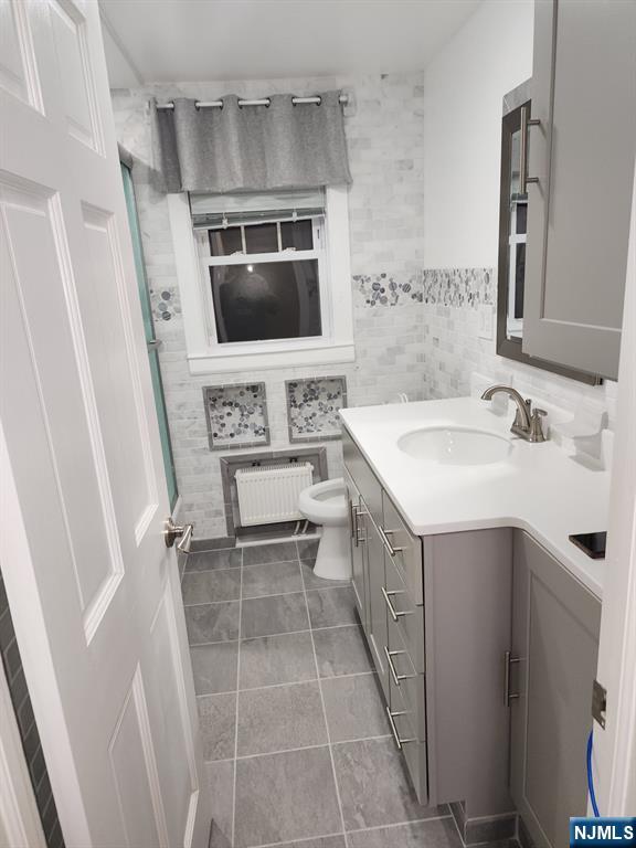 500 Weart Avenue, Unit 2 Lyndhurst, NJ 07071 - Photo 13 of 20 a bathroom with a sink a toilet a mirror and vanity