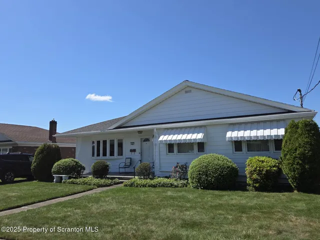 a view of a house with a big yard and potted plants