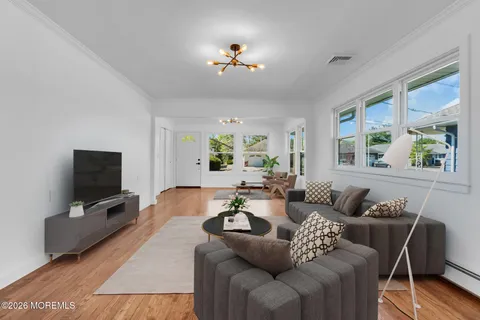 a living room with furniture a flat screen tv and a window
