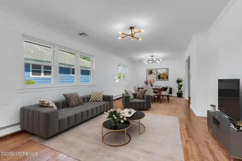 a living room with furniture kitchen view and a flat screen tv