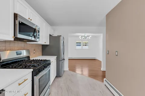 a kitchen with stainless steel appliances a microwave a stove and white cabinets