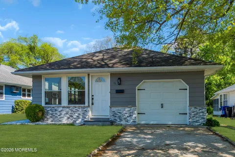 a front view of a house with a garden and yard