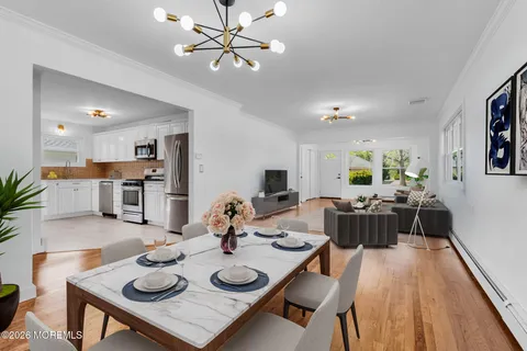 a living room with furniture kitchen view and a wooden floor