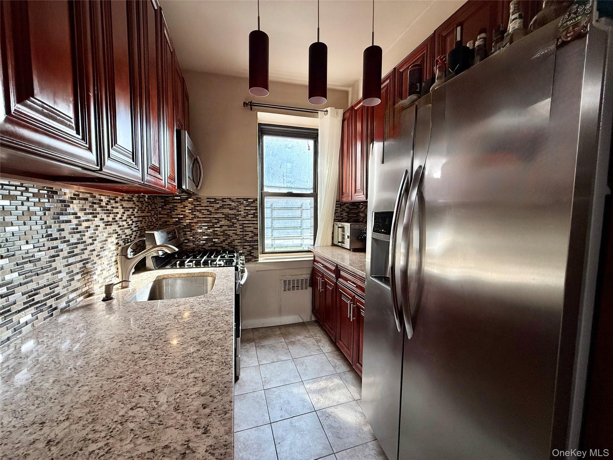 112-25 34th Avenue, Unit G Queens, NY 11368 - Photo 18 of 47 a kitchen with stainless steel appliances granite countertop a sink refrigerator and cabinets