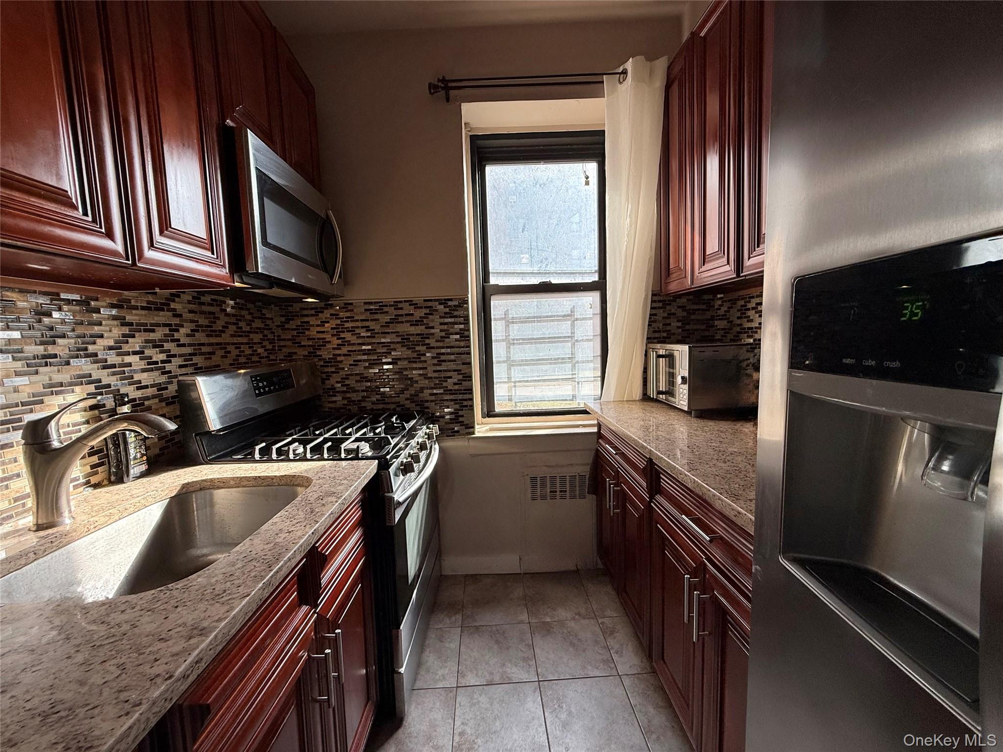 112-25 34th Avenue, Unit G Queens, NY 11368 - Photo 19 of 47 a kitchen with granite countertop a sink stainless steel appliances and cabinets