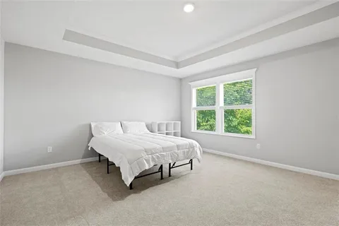 a bed sitting in a bedroom next to a window