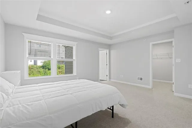 a bedroom with a bed and a large window