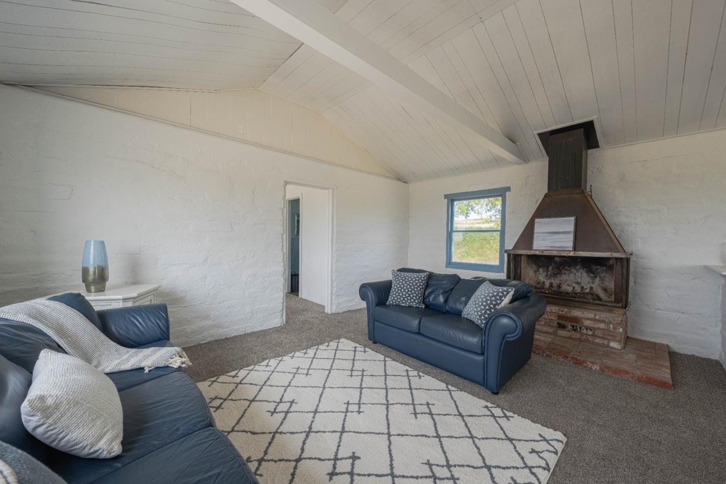 706 San Andreas Road Watsonville, CA 95076 - Photo 6 of 26 a living room with furniture and a fireplace