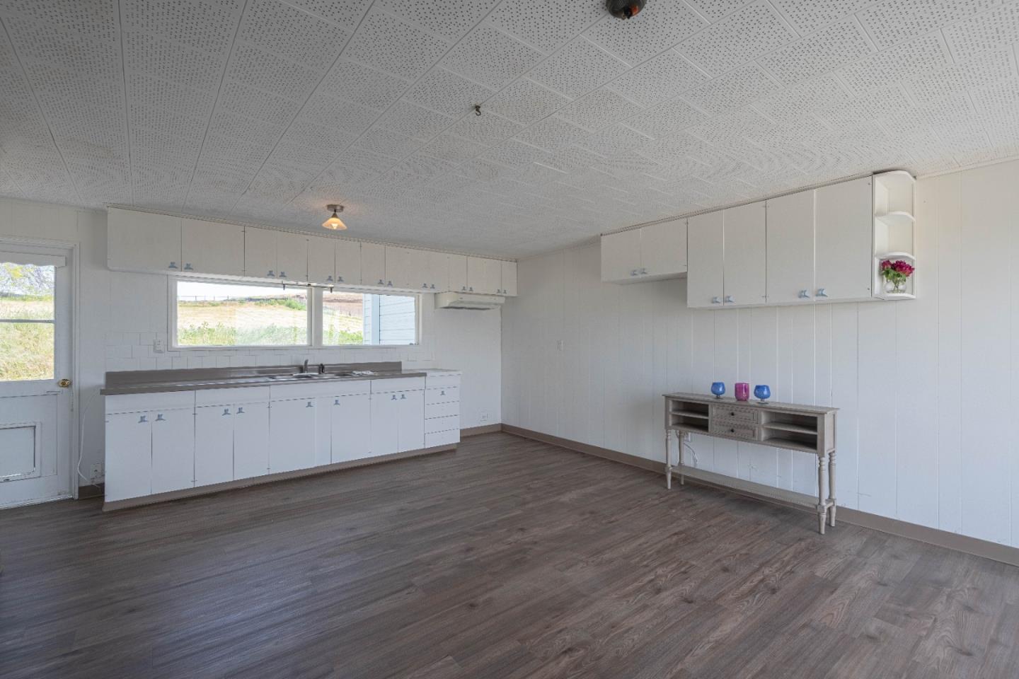 706 San Andreas Road Watsonville, CA 95076 - Photo 10 of 26 an empty room with wooden floor and windows