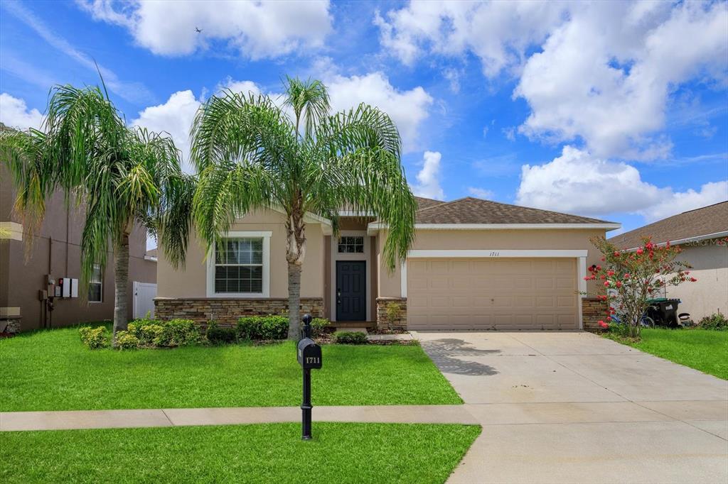 a front view of a house with a garden and yard