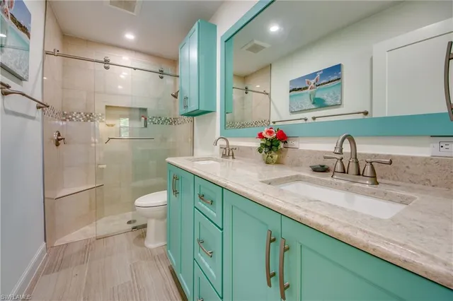 a bathroom with a sink a toilet and shower