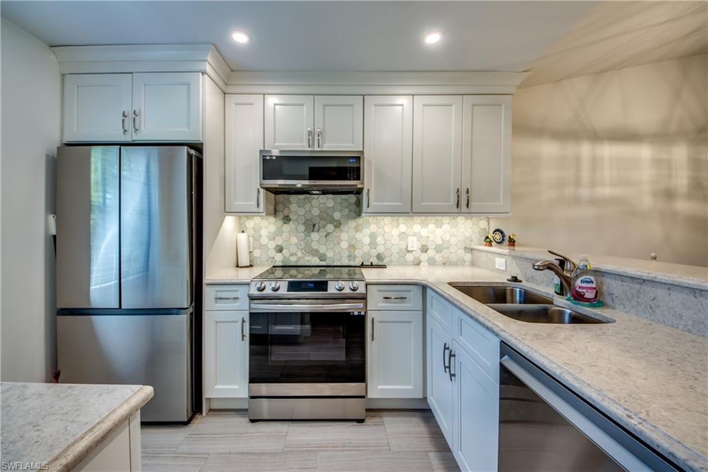 16541 Bayleaf Lane, Unit 56 Fort Myers, FL 33908 - Photo 4 of 24 a kitchen with stainless steel appliances granite countertop a refrigerator sink and stove