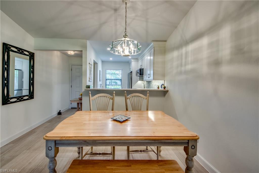 16541 Bayleaf Lane, Unit 56 Fort Myers, FL 33908 - Photo 7 of 24 a view of a dining room with furniture and a chandelier