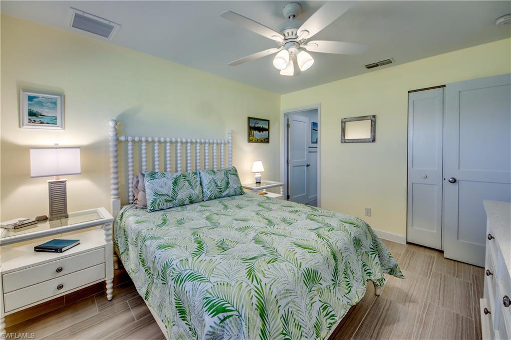 16541 Bayleaf Lane, Unit 56 Fort Myers, FL 33908 - Photo 9 of 24 a bedroom with a bed and a lamp on dresser