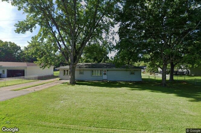 a view of a house with a yard and a large tree