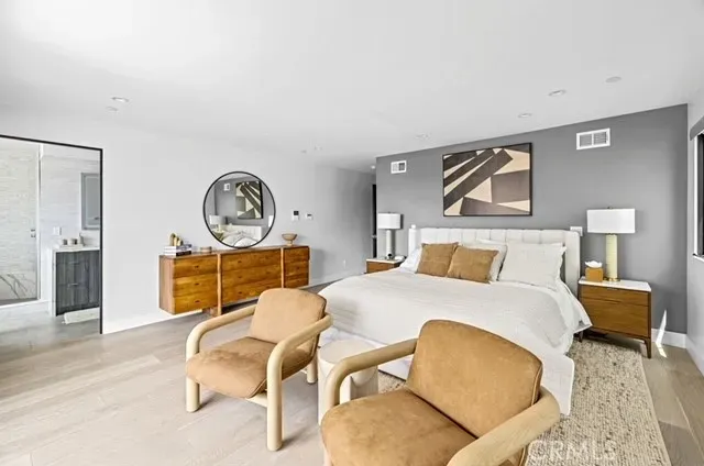 a living room with furniture a mirror and a wooden floor