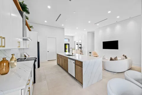 a kitchen with stainless steel appliances kitchen island wooden floors and white cabinets