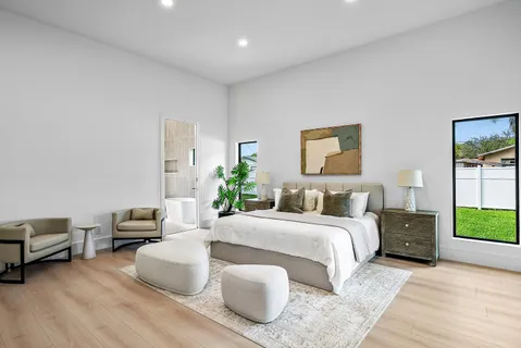 a large white room with stainless steel appliances kitchen island granite countertop a sink and chairs