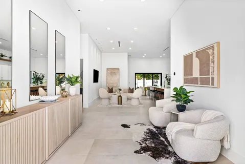 a living room with furniture potted plant wooden floor and a large window