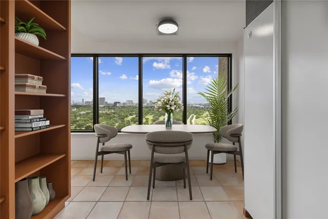a dining room with furniture and a floor to ceiling window