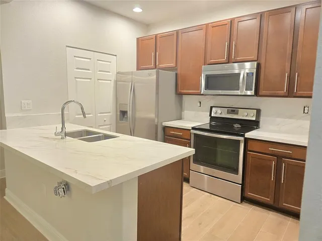 a kitchen with stainless steel appliances a sink a stove a microwave and cabinets
