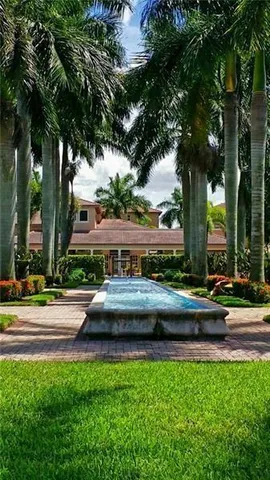 a front view of a house with a garden and trees