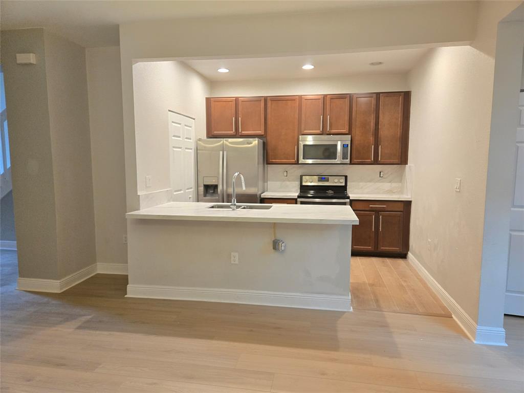 1528 Southwest 147th Avenue, Unit 1527 Pembroke Pines, FL 33027 - Photo 7 of 18 a kitchen with kitchen island a sink cabinets and stainless steel appliances