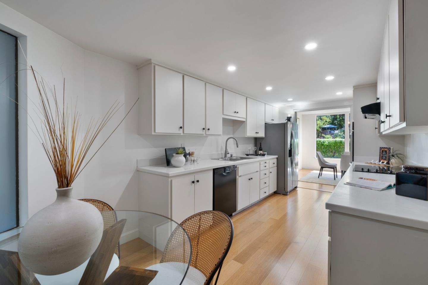 300 Sand Hill Circle, Unit 101 Menlo Park, CA 94025 - Photo 14 of 47 a kitchen with stainless steel appliances kitchen island granite countertop a sink a stove a refrigerator cabinets and a dining table with wooden floor