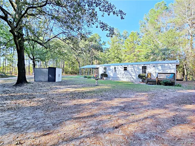 a view of a house with a yard and tree s
