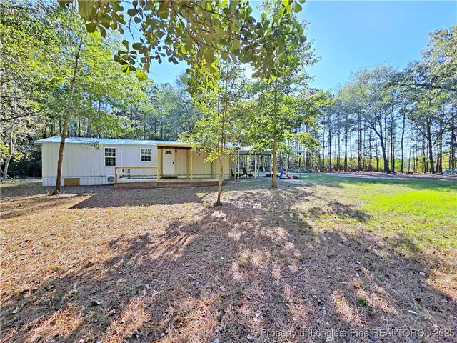 a view of a house with a yard and sitting area