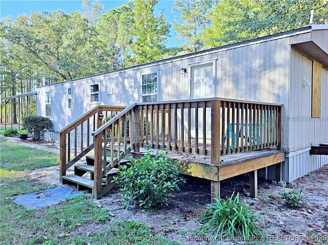 a view of a garden with wooden deck and furniture