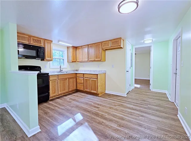 a view of a kitchen with a sink wooden floor and a living room