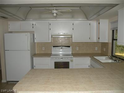 18213 Maple Road Fort Myers, FL 33967 - Photo 3 of 9 a kitchen with granite countertop white cabinets and stainless steel appliances