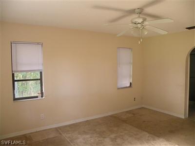 18213 Maple Road Fort Myers, FL 33967 - Photo 7 of 9 an empty room with a window and a chandelier fan