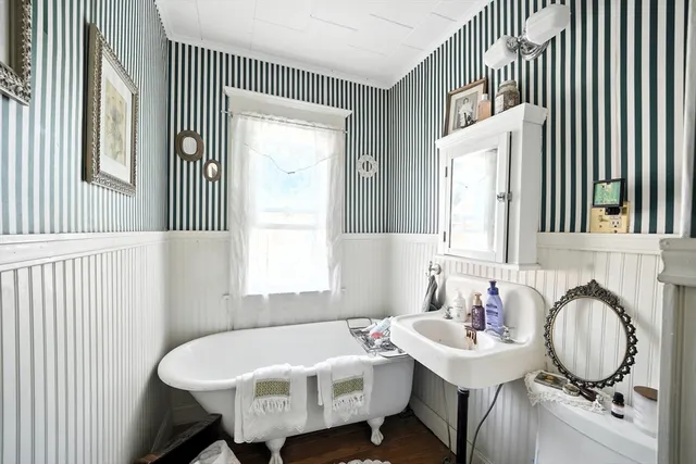 a bathroom with a sink mirror and a window