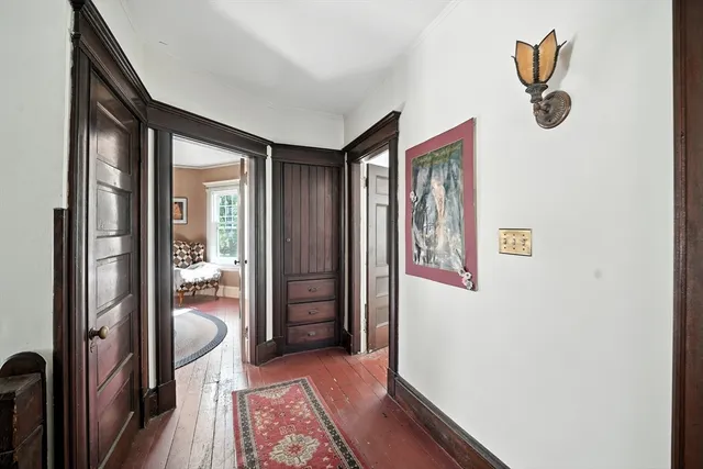 a hallway with wooden floor and windows