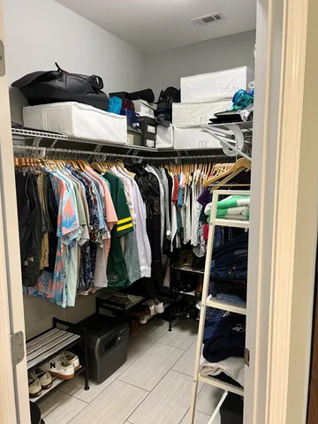 a view of walk in closet with clothes and shoes