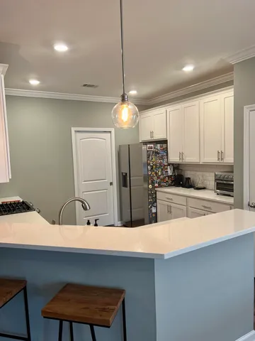 a kitchen with kitchen island a sink and a refrigerator