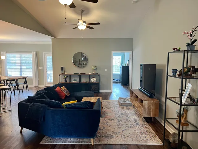 a living room with furniture wooden floor and a flat screen tv