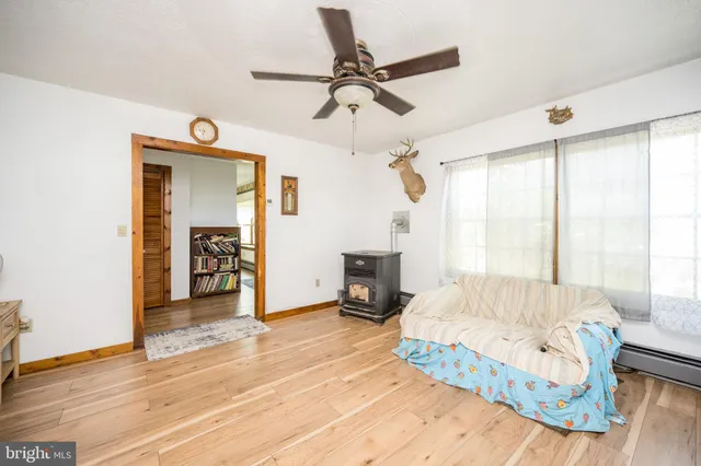 a view of a livingroom with wooden floor and a ceiling fan