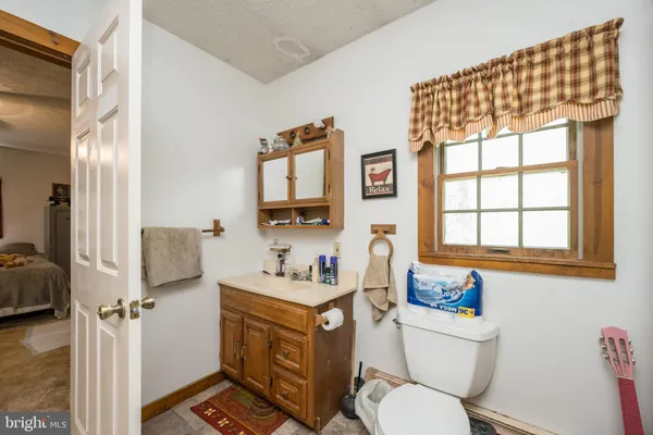 a bedroom with a bed and dresser with chair
