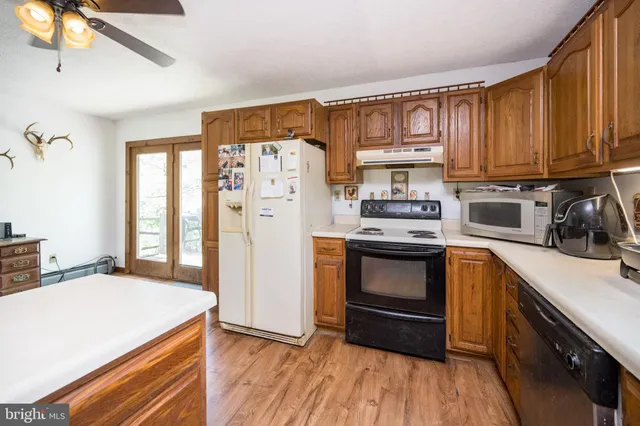 a living room with stainless steel appliances kitchen island granite countertop furniture and a large window
