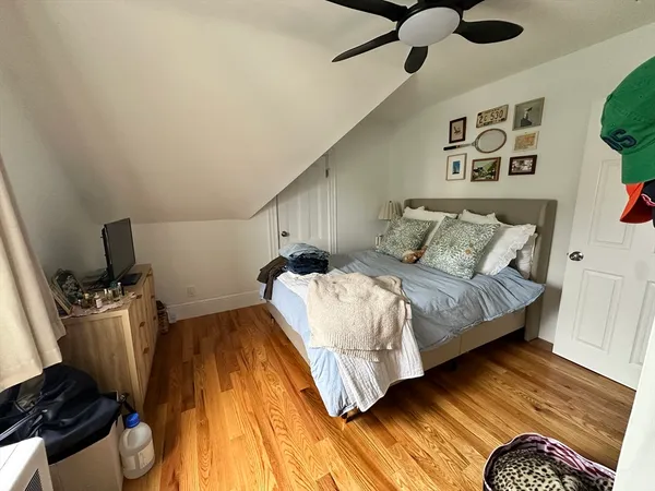 a bedroom with a bed and wooden floor