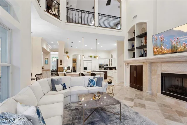 a living room with furniture a flat screen tv and a chandelier