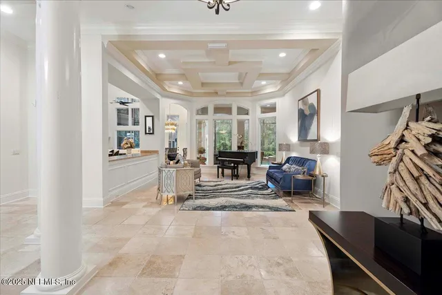 a living room with furniture kitchen view and a chandelier