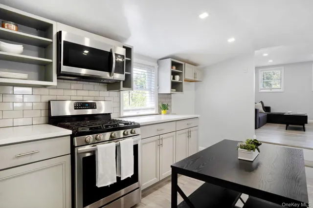 a kitchen with stainless steel appliances a stove microwave and cabinets
