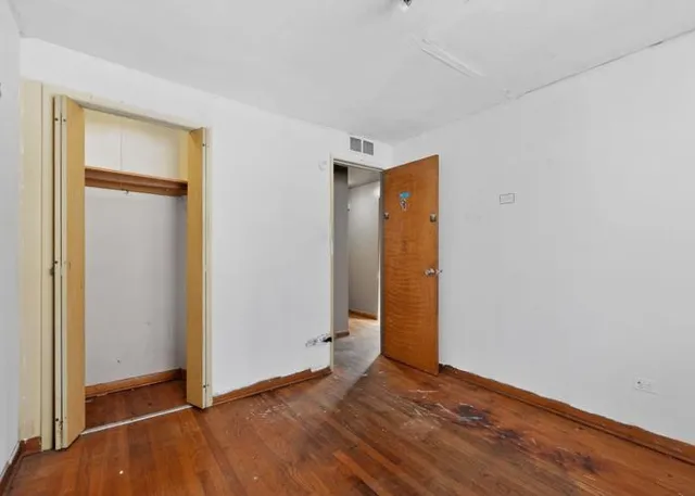a view of an empty room with closet and a window
