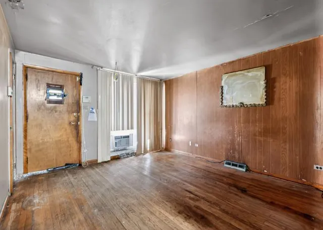 a view of a livingroom with wooden floor and kitchen space